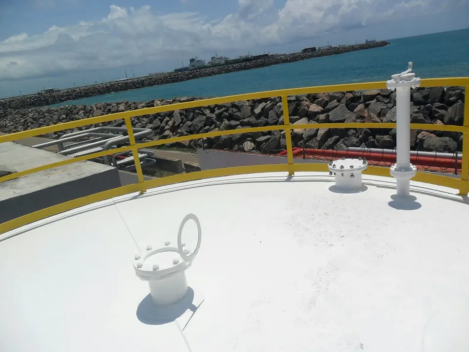 Teto do mesmo tanque recuperado e pintado de branco, com o mar ao fundo
