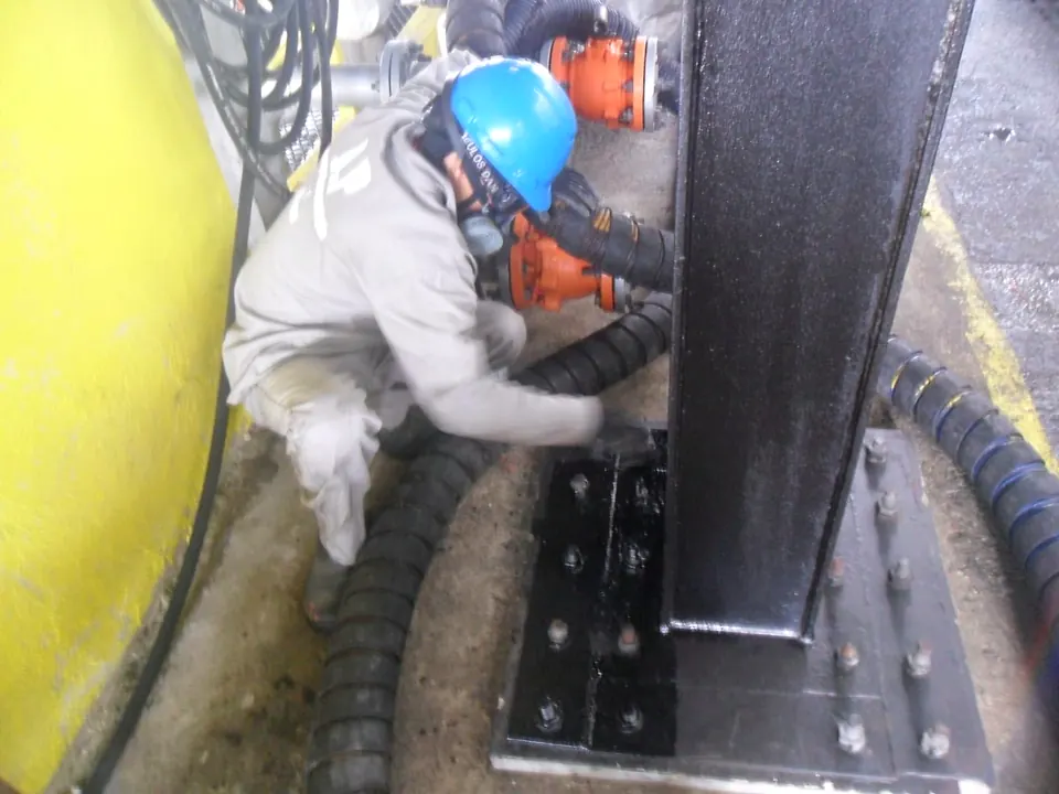 Profissional da JRP trabalhando na base de um pilar metálico da ilha de carregamento